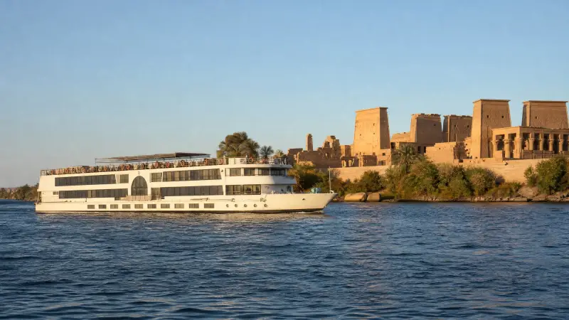 A Nile cruise ship passing an ancient temple near Aswan